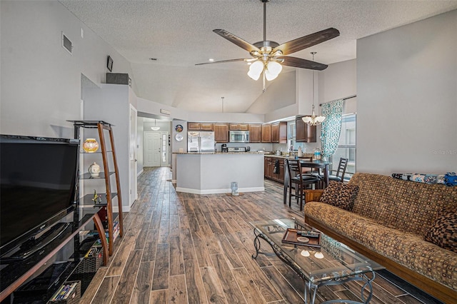 6118 Becklin Pl, Riverview, FL 33578 - living room with a textured ceiling, ceiling fan, dark wood-style floors, high vaulted ceiling, and a chandelier