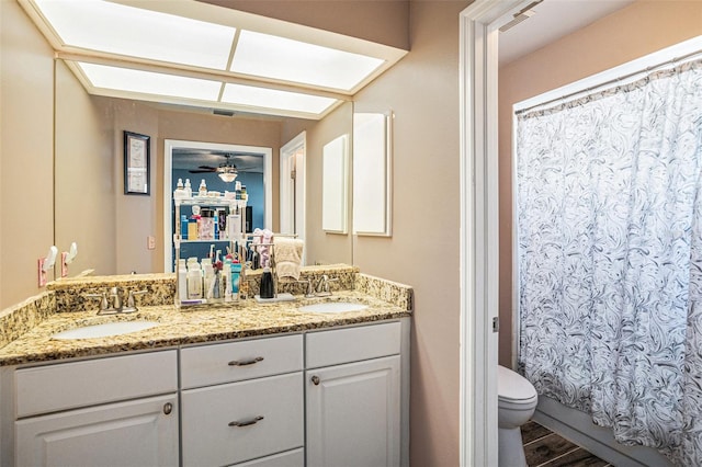 6118 Becklin Pl, Riverview, FL 33578 - full bathroom with double vanity, toilet, wood finished floors, and a ceiling fan
