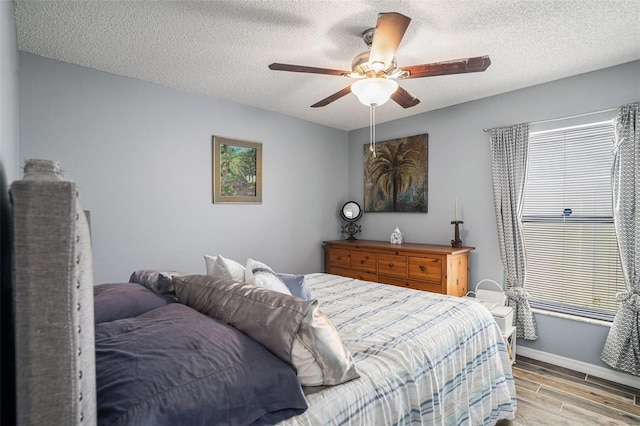 6118 Becklin Pl, Riverview, FL 33578 - bedroom with light wood-style floors, a textured ceiling, baseboards, and ceiling fan