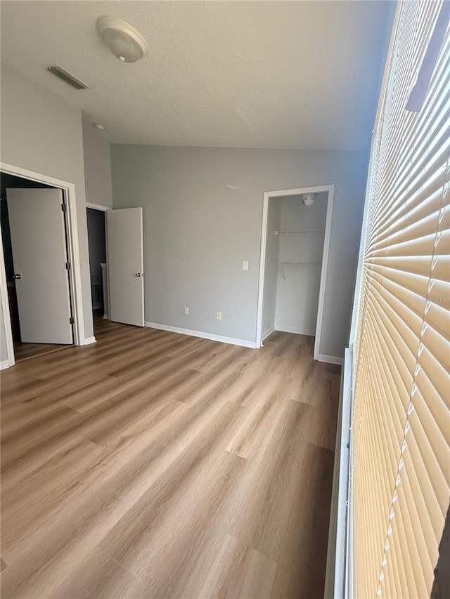 6025 Osprey Lake Cir, Riverview, FL 33578 - unfurnished bedroom featuring light wood-style flooring, a spacious closet, baseboards, and a closet