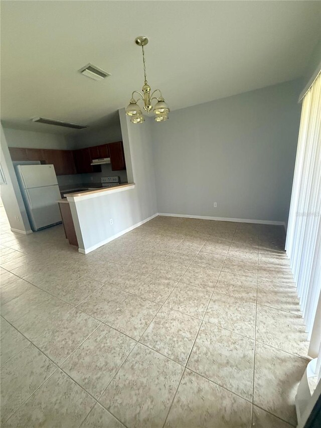 6025 Osprey Lake Cir, Riverview, FL 33578 - kitchen with freestanding refrigerator, a chandelier, light tile patterned floors, decorative light fixtures, and under cabinet range hood