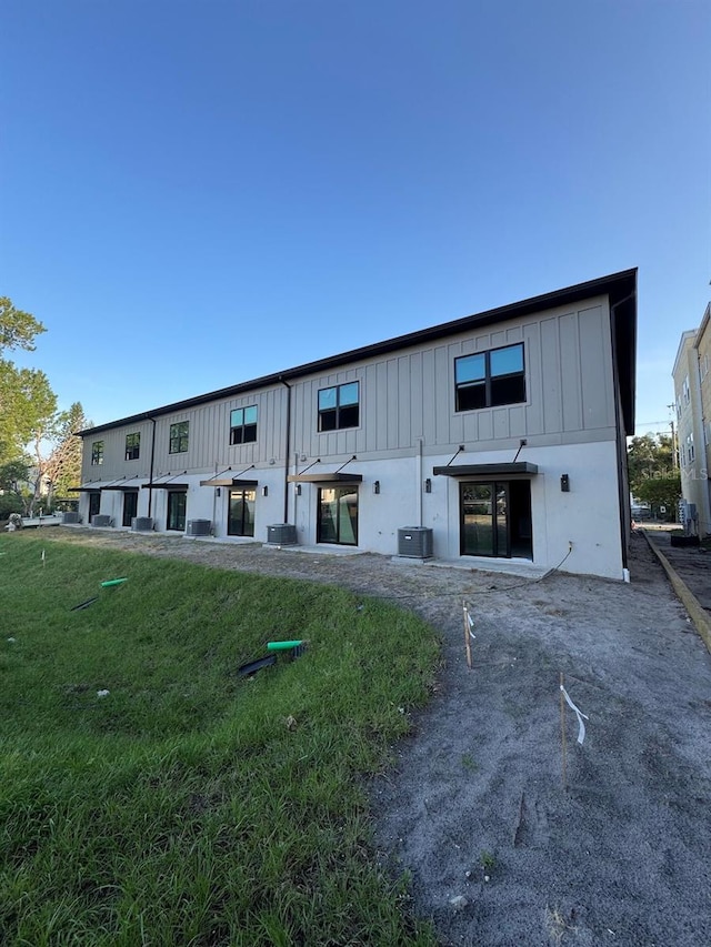 4308 W Gray St Unit 1Thru 6, Tampa, FL 33609 - rear view of property with board and batten siding, central air condition unit, and a lawn