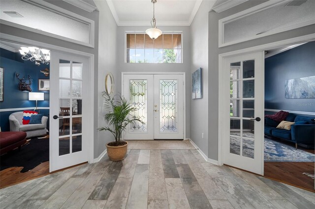 2903 Manor Ridge Pl, Valrico, FL 33596 - entrance foyer with french doors, crown molding, hardwood / wood-style flooring, a chandelier, and a towering ceiling