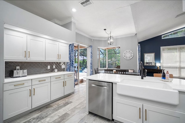 2903 Manor Ridge Pl, Valrico, FL 33596 - kitchen with dishwasher, a sink, crown molding, light countertops, and decorative backsplash