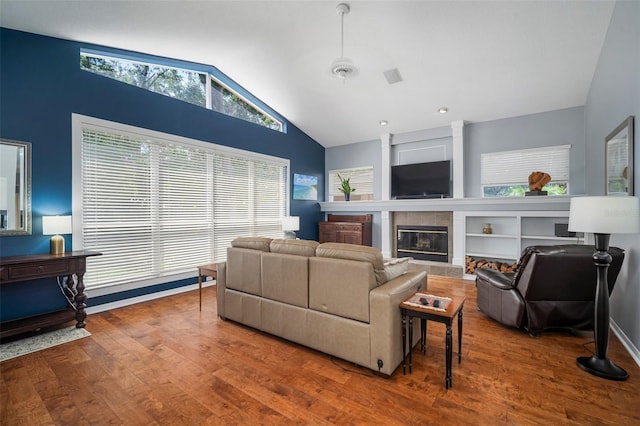 2903 Manor Ridge Pl, Valrico, FL 33596 - living room with vaulted ceiling, wood finished floors, a tiled fireplace, and baseboards