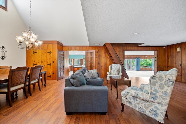 8011 N Mobley Rd, Odessa, FL 33556 - living area with wood walls, a chandelier, stairs, a textured ceiling, and wood finished floors