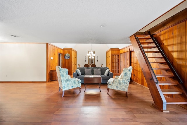 8011 N Mobley Rd, Odessa, FL 33556 - living room featuring stairs, a chandelier, a textured ceiling, wood finished floors, and wooden walls