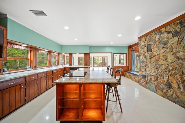 8011 N Mobley Rd, Odessa, FL 33556 - kitchen with ornamental molding, recessed lighting, a kitchen bar, black electric stovetop, and a spacious island