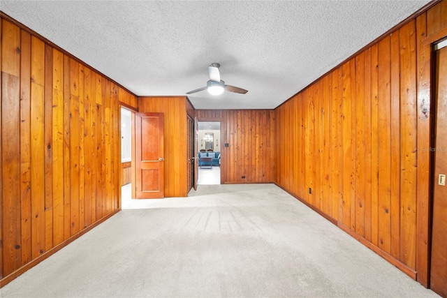 8011 N Mobley Rd, Odessa, FL 33556 - unfurnished room with a ceiling fan, wooden walls, a textured ceiling, carpet flooring, and crown molding
