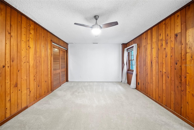 8011 N Mobley Rd, Odessa, FL 33556 - carpeted empty room with wood walls, a ceiling fan, a textured ceiling, and baseboards