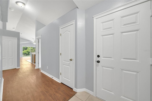entrance foyer featuring vaulted ceiling, baseboards, wood finished floors, and a ceiling fan