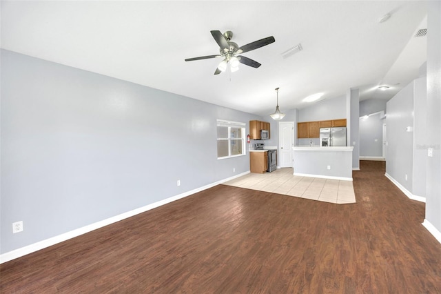 unfurnished living room featuring vaulted ceiling, light wood-style flooring, a ceiling fan, and baseboards