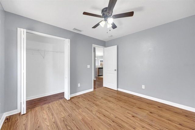 unfurnished bedroom featuring light wood-style floors, baseboards, a closet, and ceiling fan