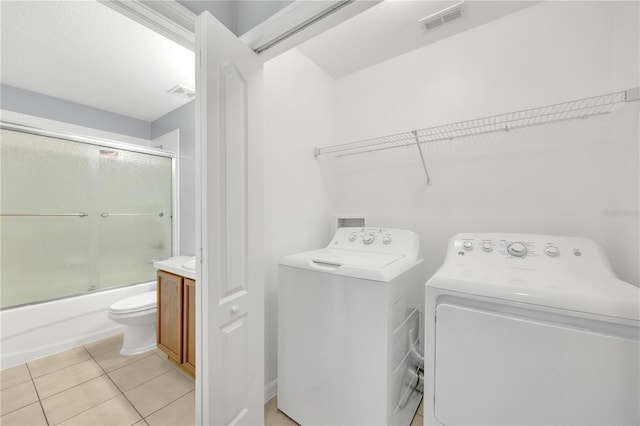 laundry room featuring washer and clothes dryer and light tile patterned floors