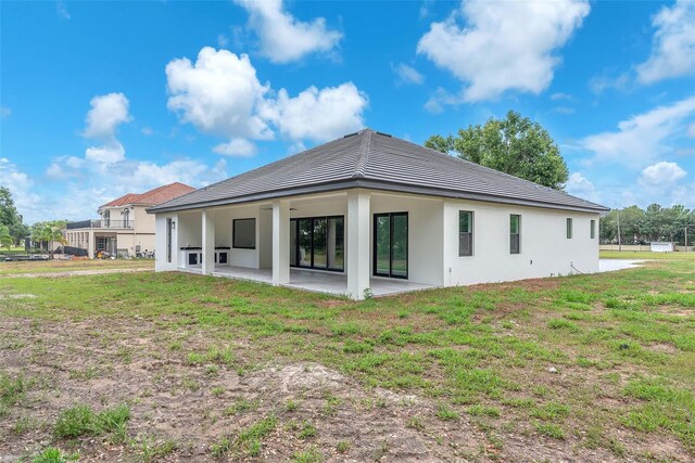 11921 Fort King Hwy, Thonotosassa, FL 33592 - back of house with a patio area, stucco siding, a yard, and a tiled roof