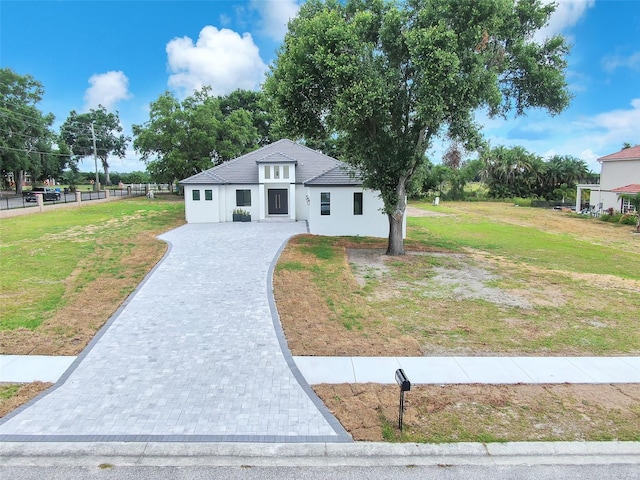 11921 Fort King Hwy, Thonotosassa, FL 33592 - view of front of house with decorative driveway, a front yard, and stucco siding
