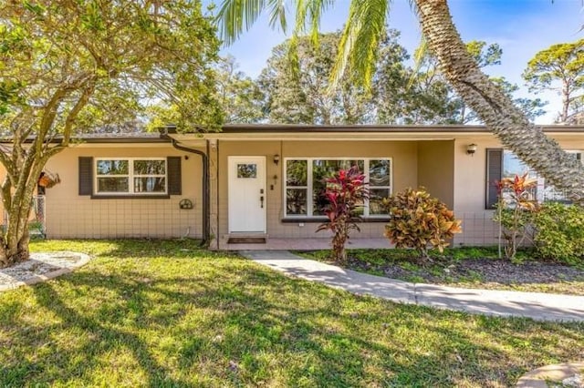 single story home featuring a front yard and stucco siding