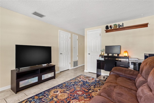 2646 61st Ave N, Saint Petersburg, FL 33714 - living room featuring a textured ceiling, a desk, and baseboards