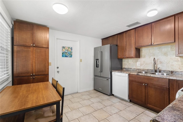 2646 61st Ave N, Saint Petersburg, FL 33714 - kitchen featuring white dishwasher, a sink, high end refrigerator, decorative backsplash, and light tile patterned floors
