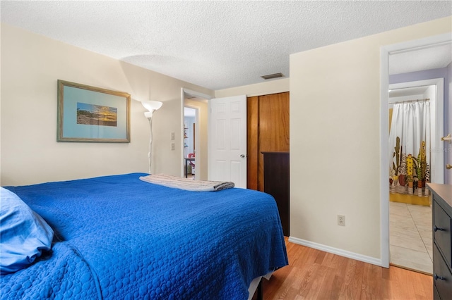 2646 61st Ave N, Saint Petersburg, FL 33714 - bedroom featuring light wood finished floors, a textured ceiling, baseboards, and a closet