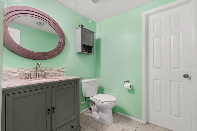 2646 61st Ave N, Saint Petersburg, FL 33714 - bathroom with vanity, toilet, baseboards, a textured ceiling, and tile patterned floors