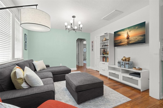 1003 W Indiana Ave, Tampa, FL 33603 - living area featuring arched walkways, built in features, a chandelier, wood finished floors, and a textured ceiling