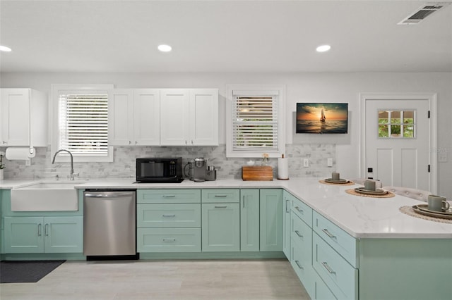 1003 W Indiana Ave, Tampa, FL 33603 - kitchen with stainless steel dishwasher, black microwave, a peninsula, healthy amount of natural light, and recessed lighting