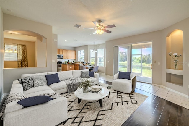 7852 Stoney Hill Dr, Wesley Chapel, FL 33545 - living area with arched walkways, ceiling fan, baseboards, wood finished floors, and built in shelves