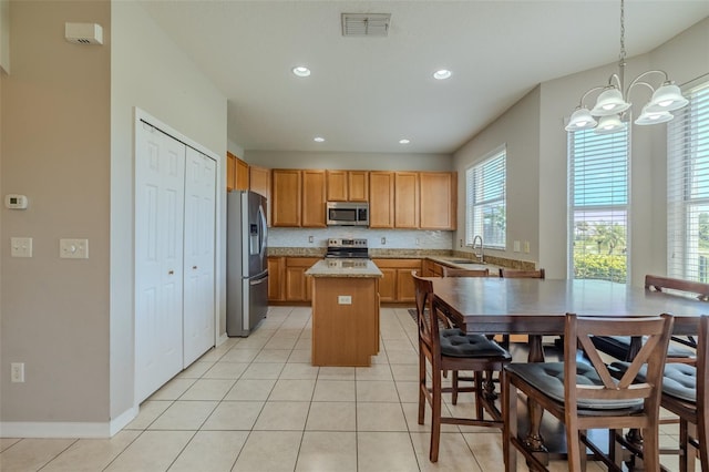 7852 Stoney Hill Dr, Wesley Chapel, FL 33545 - kitchen featuring appliances with stainless steel finishes, a chandelier, a sink, a kitchen island, and light tile patterned flooring