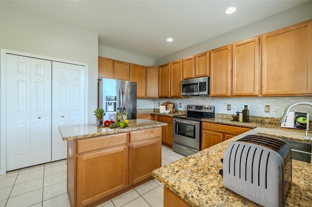 7852 Stoney Hill Dr, Wesley Chapel, FL 33545 - kitchen with appliances with stainless steel finishes, a kitchen island, light tile patterned floors, light stone counters, and recessed lighting