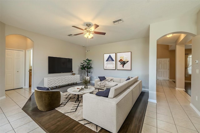7852 Stoney Hill Dr, Wesley Chapel, FL 33545 - living area with arched walkways, light tile patterned flooring, a ceiling fan, and baseboards