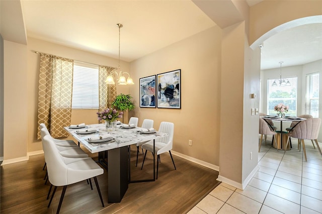 7852 Stoney Hill Dr, Wesley Chapel, FL 33545 - dining space featuring a chandelier, arched walkways, wood finished floors, and baseboards