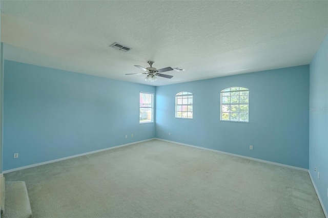 7852 Stoney Hill Dr, Wesley Chapel, FL 33545 - unfurnished room with light carpet, healthy amount of natural light, ceiling fan, baseboards, and a textured ceiling