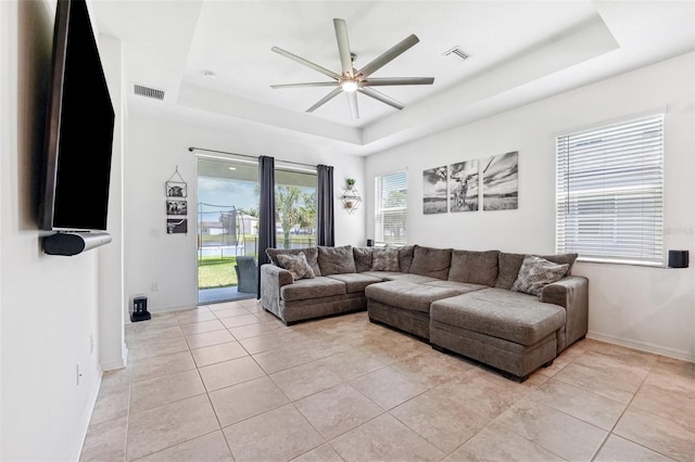 8496 Starlight Loop, Parrish, FL 34219 - living area featuring a raised ceiling, a ceiling fan, light tile patterned floors, and baseboards