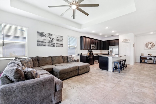 8496 Starlight Loop, Parrish, FL 34219 - living room with a tray ceiling, a ceiling fan, recessed lighting, and light tile patterned floors