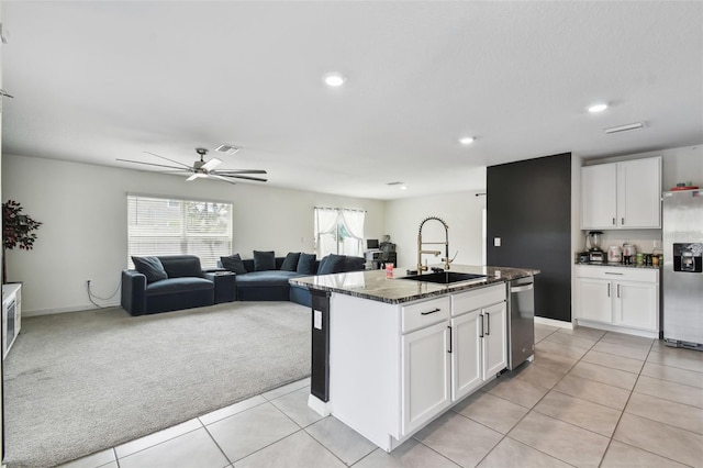 kitchen featuring stainless steel appliances, a sink, a ceiling fan, white cabinetry, and light carpet