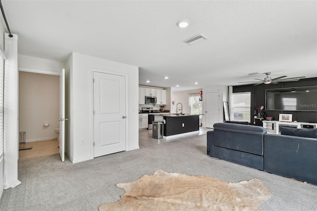 living area with light carpet, a ceiling fan, recessed lighting, and baseboards