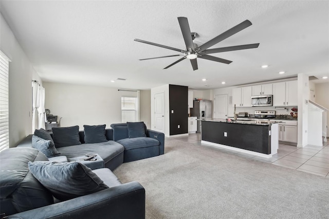 living room with a ceiling fan, light tile patterned flooring, recessed lighting, and a textured ceiling