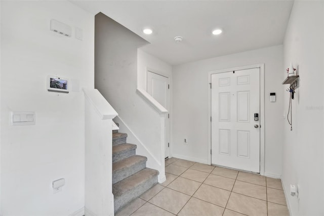 entrance foyer featuring light tile patterned flooring, stairs, baseboards, and recessed lighting