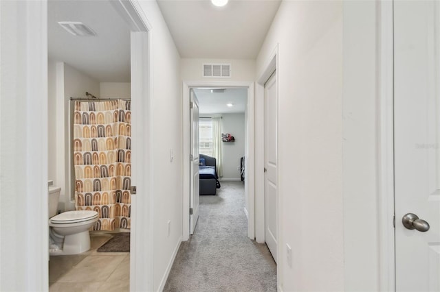 corridor with baseboards and carpet