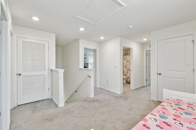 carpeted bedroom with attic access, baseboards, recessed lighting, and ensuite bath