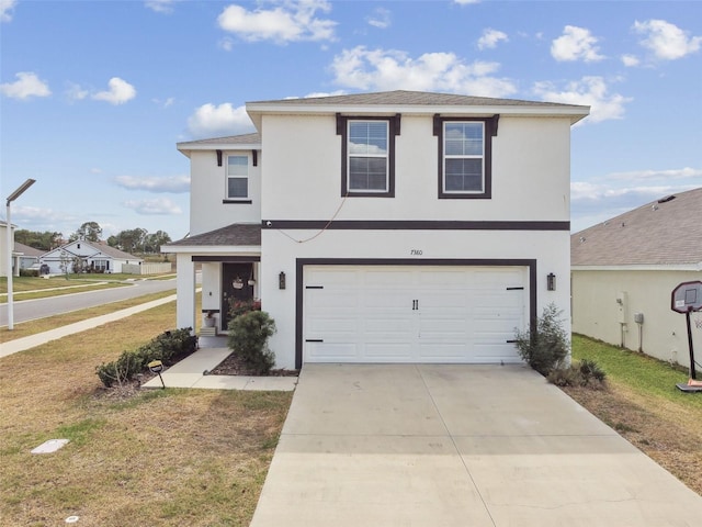 traditional home featuring stucco siding, driveway, and a front yard