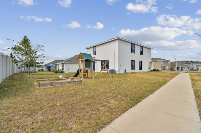 back of house with a playground, stucco siding, and central AC