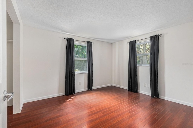12019 106th Ct, Largo, FL 33778 - empty room with plenty of natural light, wood finished floors, and a textured ceiling