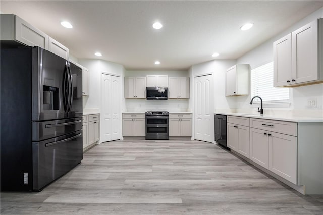 14384 NW 160th Ln, Alachua, FL 32615 - kitchen with stainless steel appliances, a sink, light wood-type flooring, light countertops, and recessed lighting