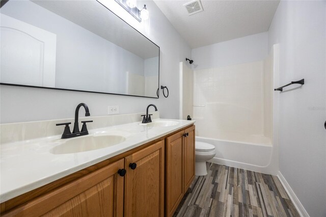 14384 NW 160th Ln, Alachua, FL 32615 - bathroom featuring wood finished floors, toilet, double vanity, shower / tub combination, and baseboards