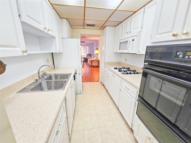 2850 59th St S Unit 310, Gulfport, FL 33707 - kitchen featuring white appliances, a sink, white cabinets, light countertops, and a drop ceiling