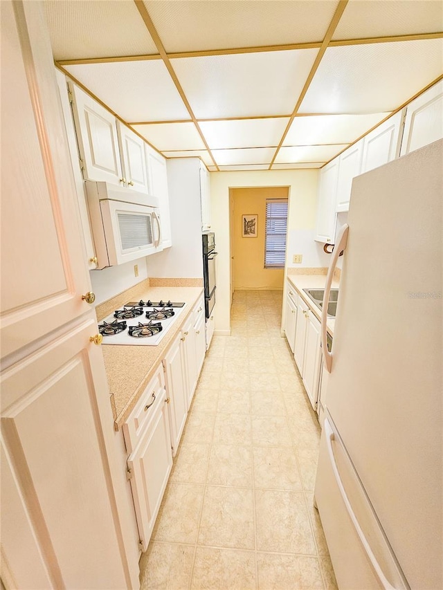 2850 59th St S Unit 310, Gulfport, FL 33707 - kitchen with white appliances, light countertops, and white cabinets