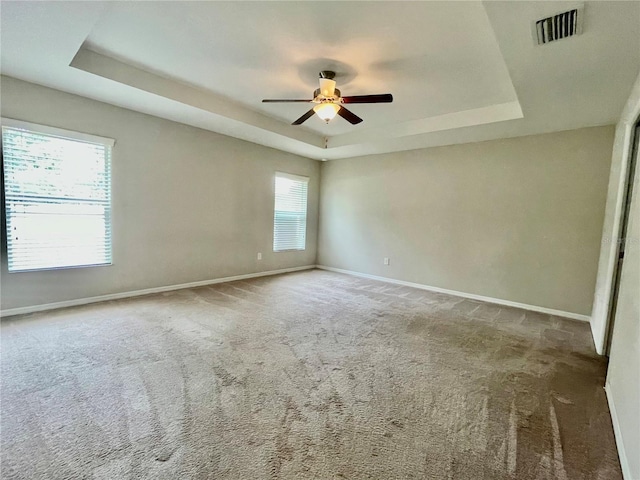 6376 SW 117th Street Rd, Ocala, FL 34476 - spare room featuring a tray ceiling, a ceiling fan, baseboards, and carpet flooring