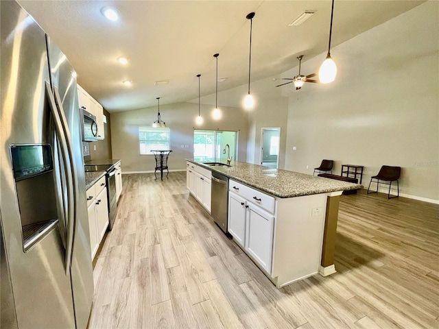 6376 SW 117th Street Rd, Ocala, FL 34476 - kitchen with stainless steel appliances, lofted ceiling, light wood-style flooring, white cabinetry, and a sink